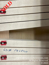 Stacked piano keys with felts, red felt bushings visible, and handwritten numbering on the side, possibly indicating a part or serial number related to piano manufacturing or repair.