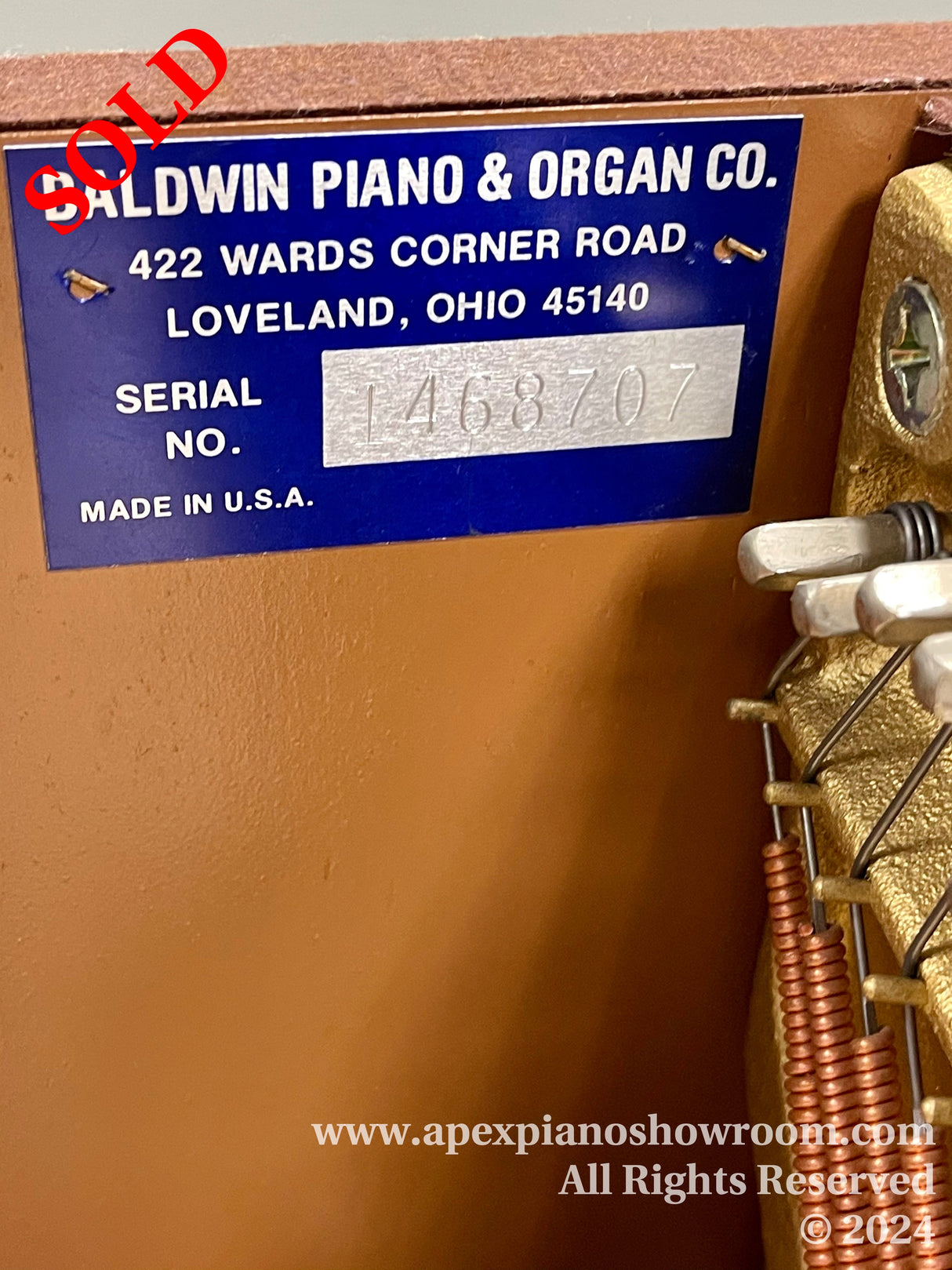 Manufacturer's information plate on a Baldwin piano indicating it is made by the Baldwin Piano & Organ Co., located in Loveland, Ohio, with the serial number 1468707, made in the U.S.A.