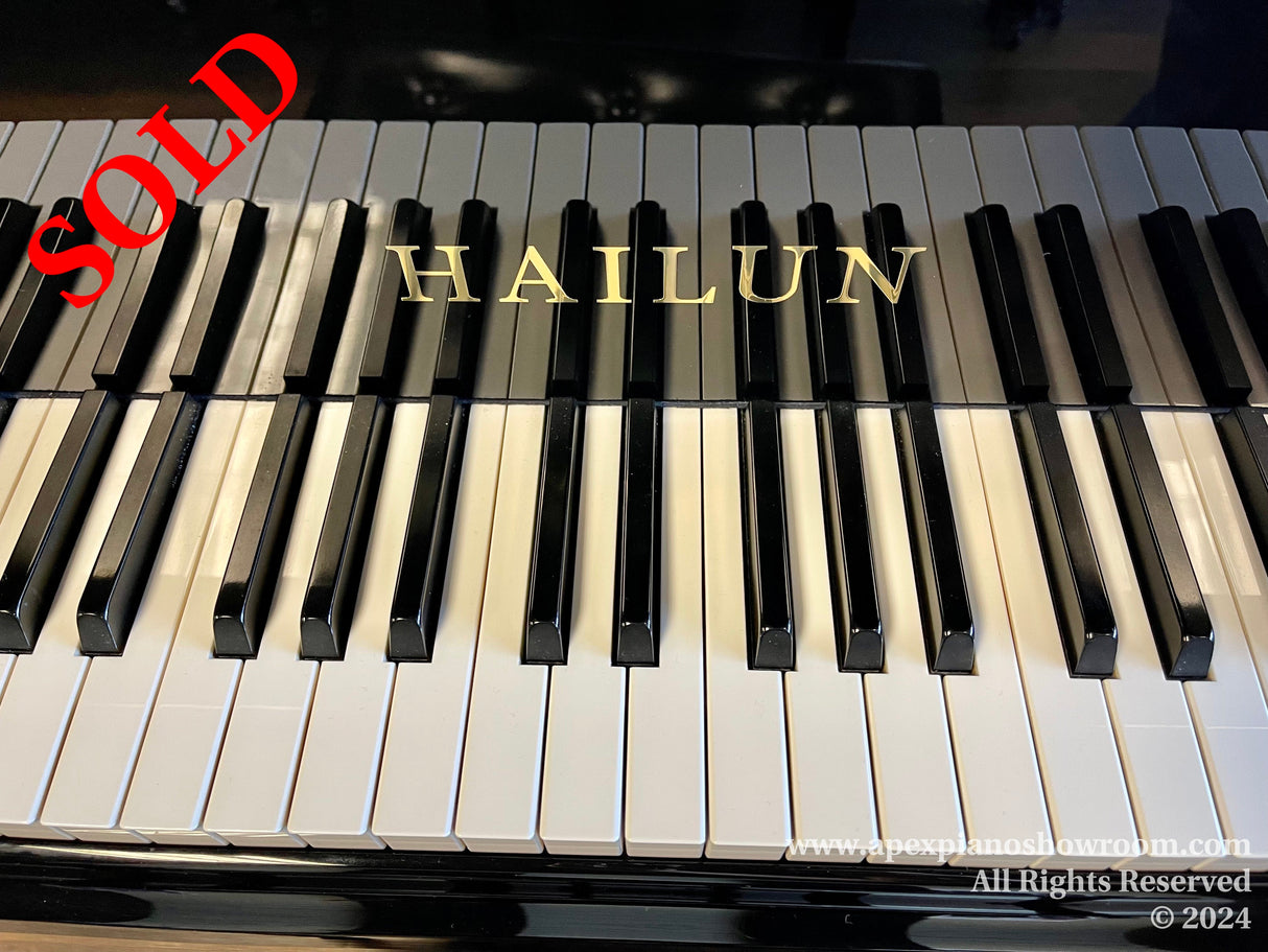 Close-up view of a Hailun piano keyboard with black and white keys, highlighting the brand name in gold lettering on the fallboard.