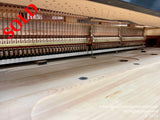 Interior view of a grand piano showing the strings and hammers, with focus on the intricate mechanism and finely crafted wooden components.