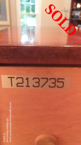 A close-up view of a pianos serial number plate, T213735, indicating its unique identity within the piano manufacturing registry.