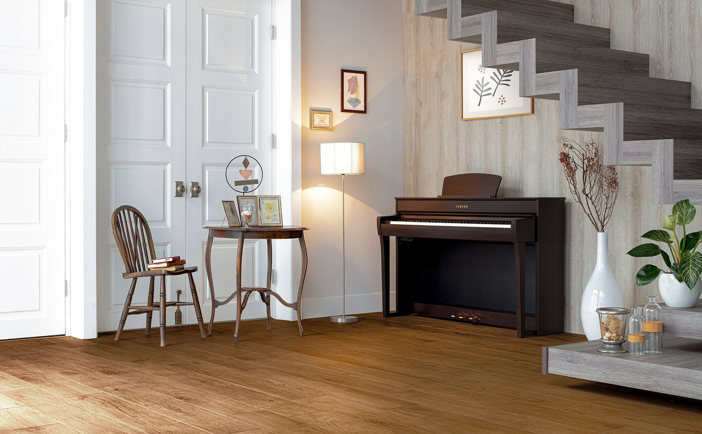 Modern digital piano by Yamaha placed in a well-lit living room with elegant home decor, reflecting a contemporary style suitable for both practice and performance in a domestic setting.