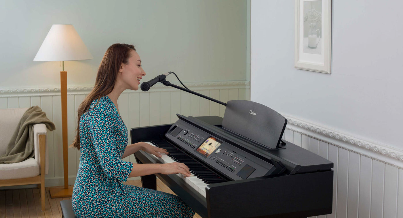 Woman playing a digital piano and singing into a microphone in a home setting.