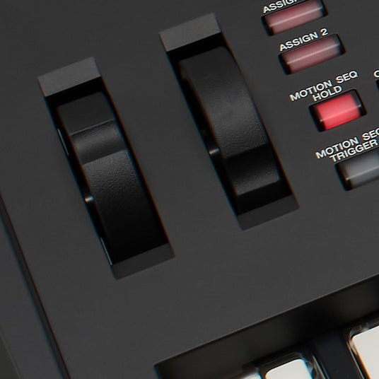 Close-up view of black keys on a modern digital piano with assignable buttons for music production.