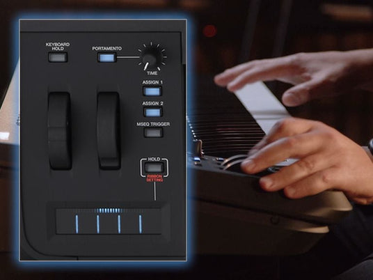 Close-up view of a musician's hand playing a digital piano with visible pitch bend and modulation controls.