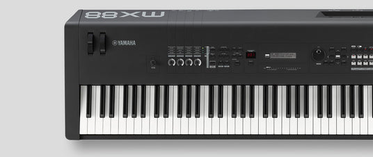 A Yamaha digital piano with 88 weighted keys, dials for controlling volume and other settings, and a LED display indicating the currently selected sound preset.