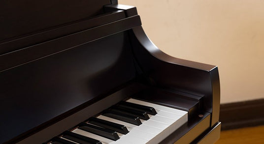 Close-up view of a black Yamaha P22 upright piano. The image shows the upper portion of the piano, including the sleek curved edge of the cabinet, the polished black finish, and a section of the keyboard with white and black keys visible.