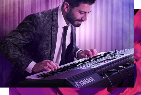A musician performing on a Yamaha electronic keyboard against a purple background.
