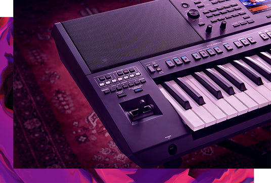 Close-up of a modern electronic keyboard with illuminated buttons and controls, set in a room with ambient purple lighting.
