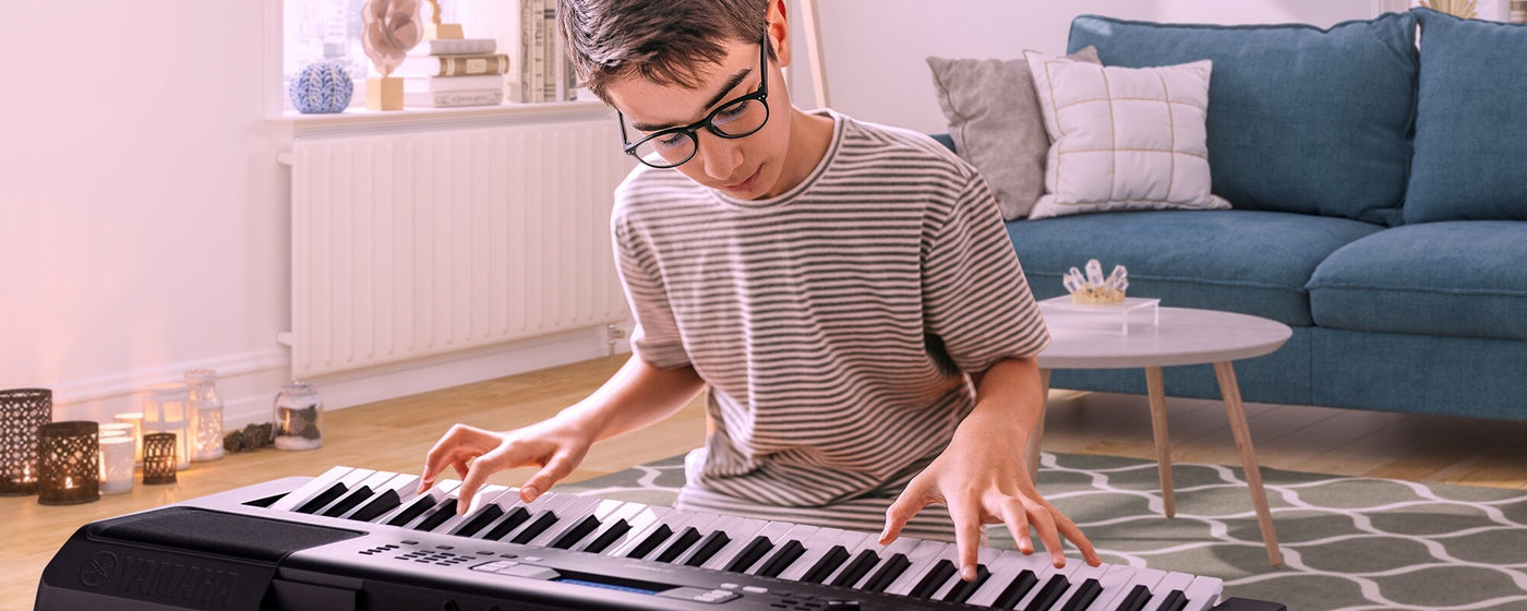 Young musician practicing on a digital piano in a cozy living room setup.