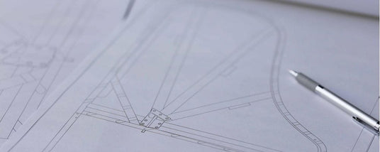 Blueprint of a grand piano design with a focus on the intricate layout of the frame and strings, accompanied by a mechanical pencil on the drafting paper.