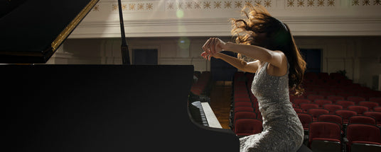 Pianist performing passionately on a grand piano on stage in an elegant concert hall.