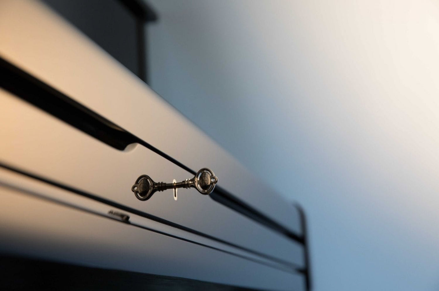 Close-up view of a piano lid prop stick with a blurred background, showcasing part of the piano's sleek black finish.