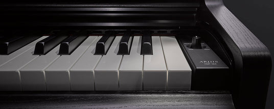 Close-up view of black and white piano keys with the name 'ARIUS' on an electronic piano.
