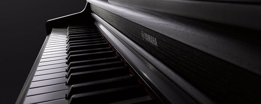 Close-up of a black Yamaha piano keyboard with focus on the keys and brand name.